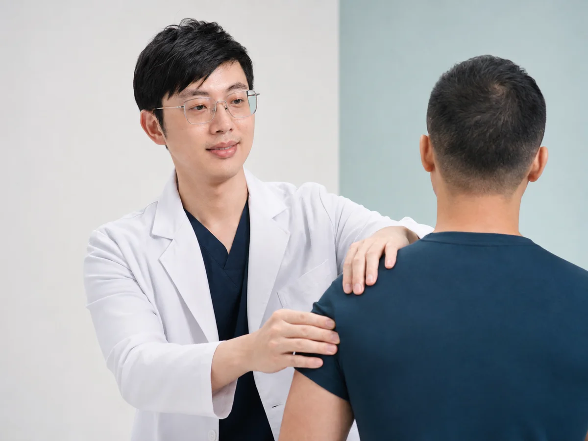 包栢嘉醫師進行觸診與身體張力評估的情境照